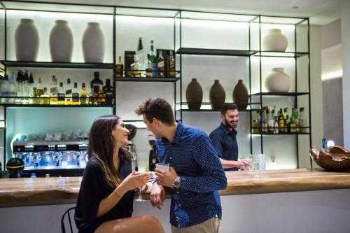 a group of people standing at a bar at Kefalonia Grand in Argostoli