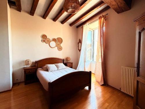 a bedroom with a bed and a large window at gîte Chez Joëlle in Les Riceys