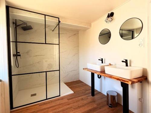 a bathroom with two sinks and a glass shower at gîte Chez Joëlle in Les Riceys