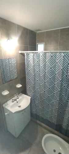 a bathroom with a sink and a toilet and a mirror at Deptosuno in General Roca