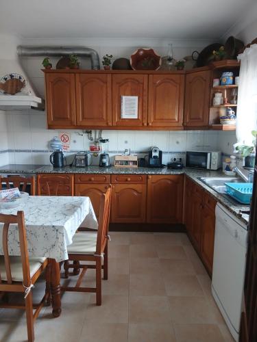 a kitchen with wooden cabinets and a table in it at Casa Afonso in Lagos