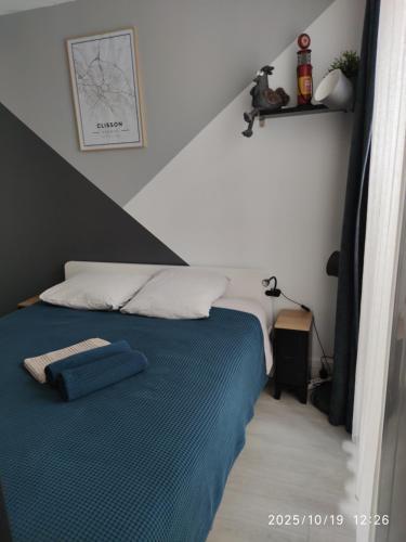 una camera da letto con un letto con una coperta blu di Escale à Clisson - L'atelier a Clisson