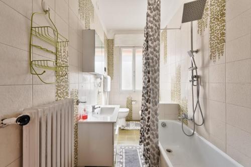 a bathroom with a white tub and a sink and a shower at Cozy Best Appartment in Marghera
