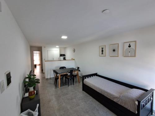 a bedroom with a bed and a dining room with a table at Deptosuno in General Roca