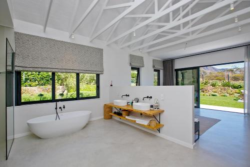 a bathroom with a large white tub and a sink at Table Mountain and Constantiaberg view in Sweet Valley