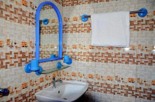 a bathroom with a sink with a mirror and a towel at New Benin Home in Benin City