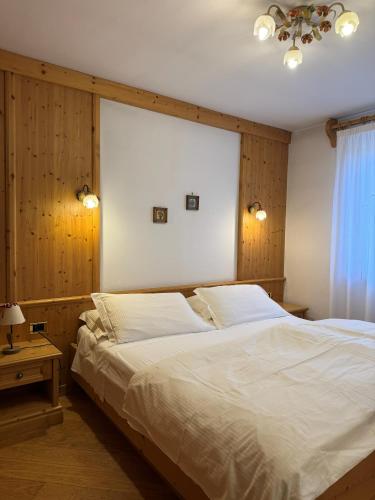 a bedroom with two white beds and a window at Campiglio Bilocale Dolomiti in Madonna di Campiglio