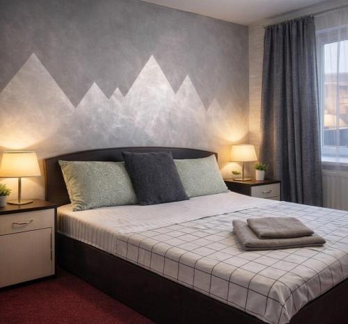 a bedroom with a large bed with mountains painted on the wall at Panorama H2O Self Check-in Pool in Korosten