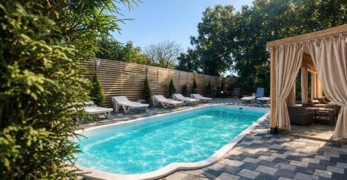 a swimming pool with chaise lounge chairs and a patio at Panorama H2O Self Check-in Pool in Korosten