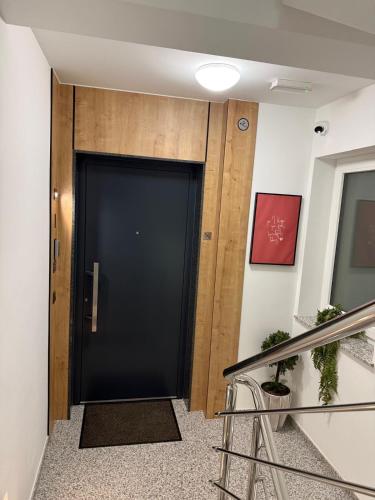 a black door in a hallway with stairs at Luxury apartment Gabi 1 in Slavonski Brod