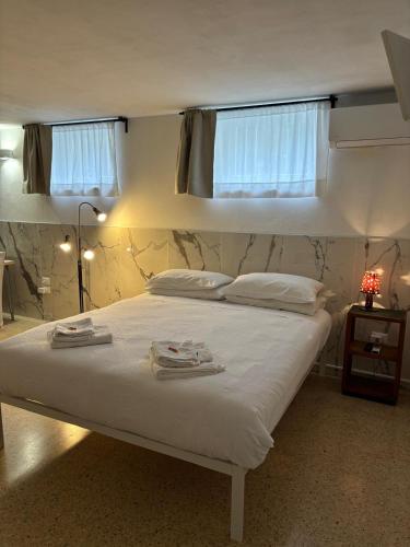 a bedroom with a white bed with towels on it at da Melina in Parma