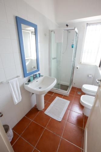 a white bathroom with a sink and a shower at SeaSide Paradise - Seafront Terrace Apartment by BariHouses in Cozze