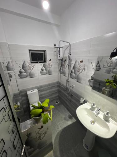 a bathroom with a sink and a tv on the wall at Kandy Green Nature Villa in Kandy