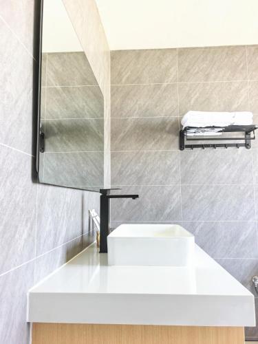 a bathroom with a white sink and a mirror at Hotel Kyson 凯森酒店 in Cocody