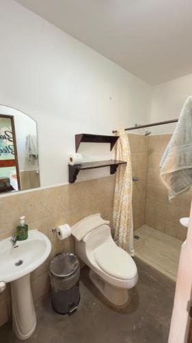 a bathroom with a toilet and a sink at Casa la barra surf resort in Miramar