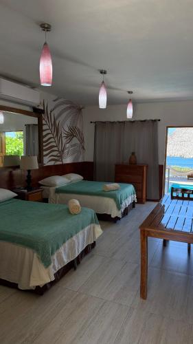 a hotel room with two beds and a table at Casa la barra surf resort in Miramar
