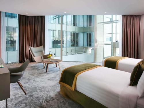 a hotel room with two beds and a bathroom at Ibis Styles Dubai Jumeira in Dubai