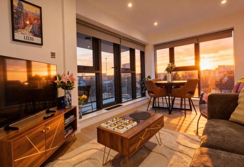 a living room with a couch and a tv and a table at Luxury 2BR Penthouse-1, Private Terrace, City Center, Free Parking in Leeds