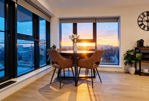 a dining room with a table and chairs and large windows at Luxury 2BR Penthouse-1, Private Terrace, City Center, Free Parking in Leeds