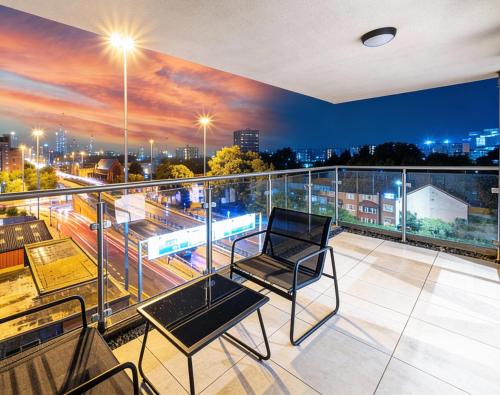 a balcony with two chairs and a view of a city at Luxury 2BR Penthouse-1, Private Terrace, City Center, Free Parking in Leeds