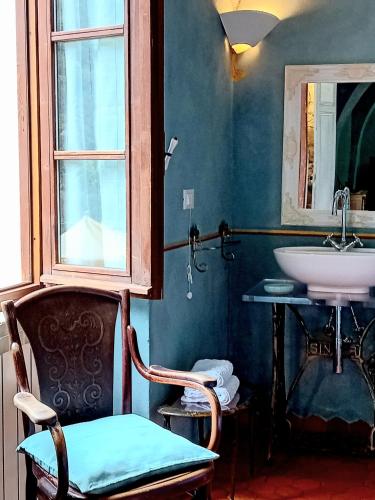 a bathroom with a chair and a sink at La Casa Rosa in Pigna