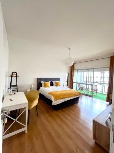 a bedroom with a bed and a table with a chair at Martins' Happy Home in Coimbra