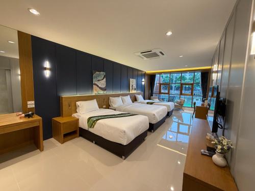 a bedroom with two beds and a television in it at THE O-ZONE AIRPORT Riviera Lodge in Lat Krabang
