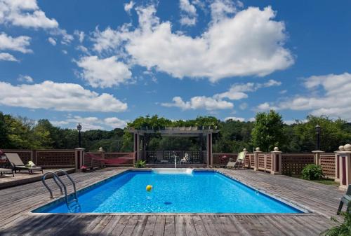 a swimming pool on a wooden deck with a blue sky at Inn at Lake Joseph in Forestburgh