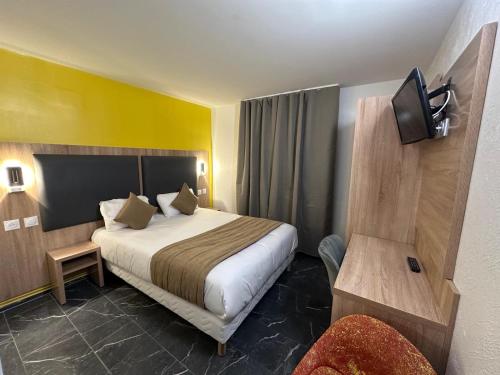 a hotel room with a bed and a tv at NOROTEL Eco in Brumath
