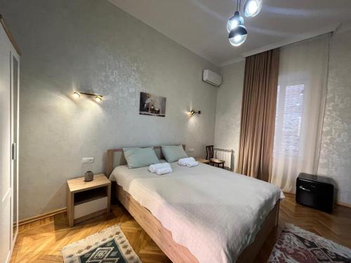 a bedroom with a large bed with two towels on it at Old Balcony in Kutaisi