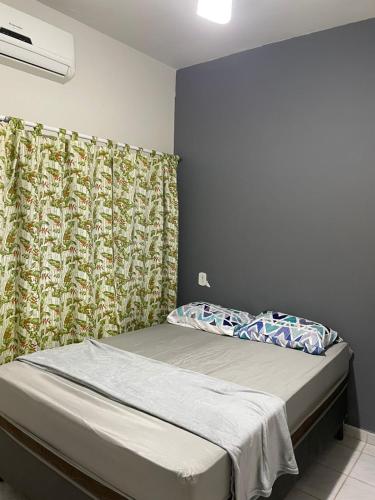 a small bedroom with a bed with a curtain at Pousada Mirante do Sol in Piúma