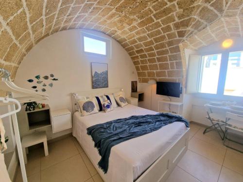 a bedroom with a bed in a brick wall at La Chicca di Fiore - Guest House in Gallipoli