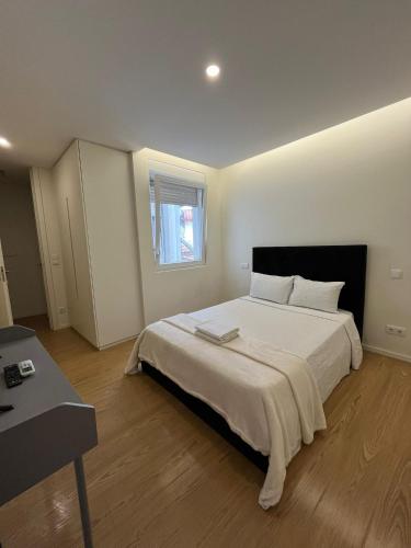a bedroom with a large white bed with a window at Casa Augusta 4 in Braga