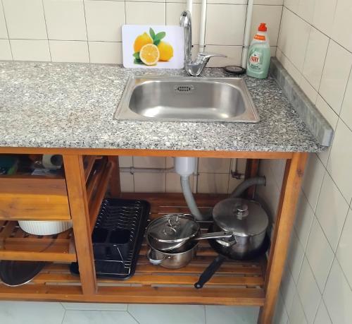 a kitchen counter with a sink and some pots and pans at Anexo na Quintinha in Caldas da Rainha