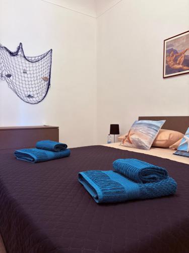 two blue pillows on top of a bed at Domus Maris in Cefalù