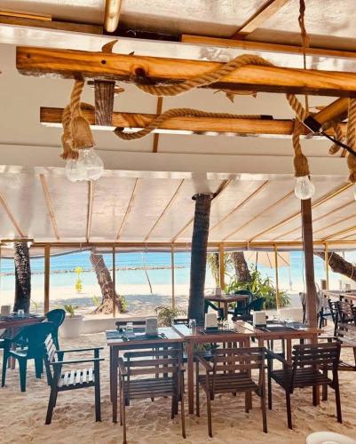 a restaurant with tables and chairs and the beach at Island Break in Fulidhoo