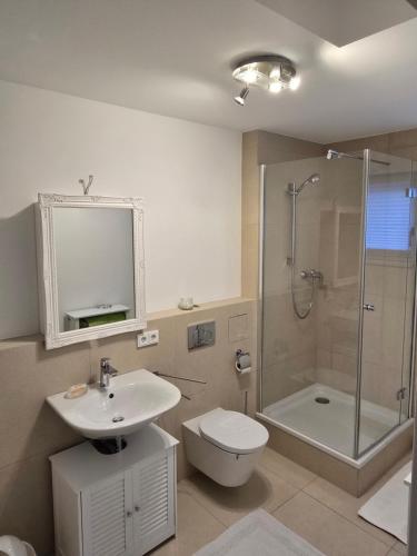 a bathroom with a sink toilet and a shower at Utting Schulstrasse in Utting am Ammersee