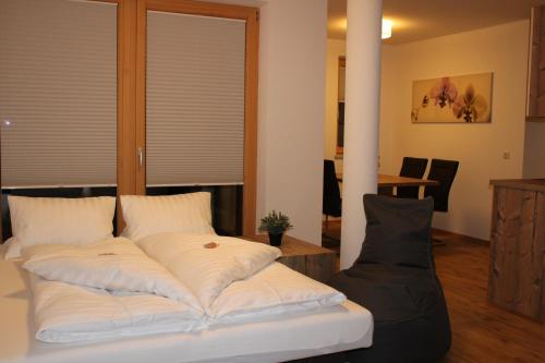 a bed with white pillows in a room at Bergchalet Rauch in Arzl im Pitztal