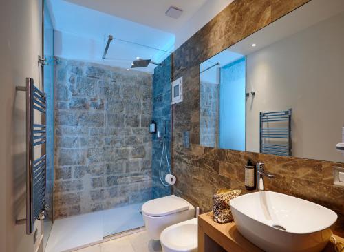 a bathroom with a sink and a toilet and a mirror at Mamaco Trani Homey in Trani