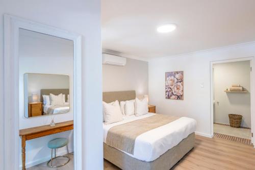 una camera da letto con un grande letto e uno specchio di Brenaissance Wine & Stud Estate a Stellenbosch
