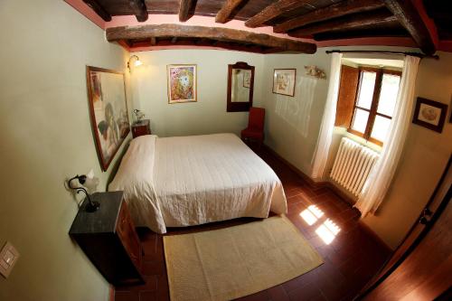 a bedroom with a white bed and a window at Tuscany Villa Chianti Hills - Villa Oliveta in Loro Ciuffenna