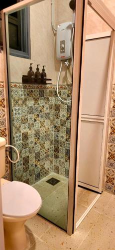 a shower with a glass door in a bathroom at KRS Pines GuestHouse in Cameron Highlands