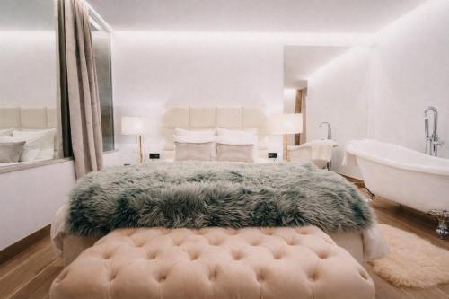a bedroom with a large bed and a bath tub and a bath tub at Casa Albarari Boutique Double Rooms with access to shared Infinity Pool in Sanxenxo