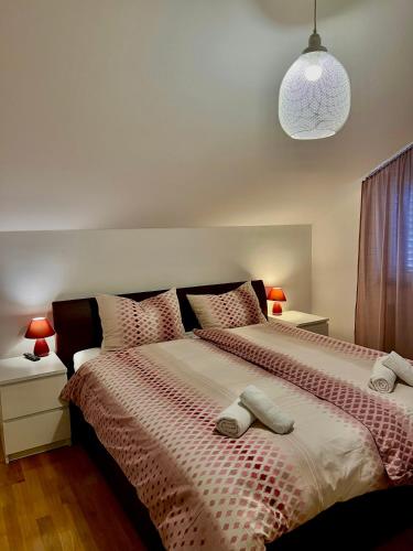 a bedroom with a bed with two slippers on it at Apartments KIDS in Kaštela
