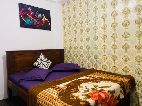 a small bedroom with a bed with purple sheets at Ivory guest house in Pattipola