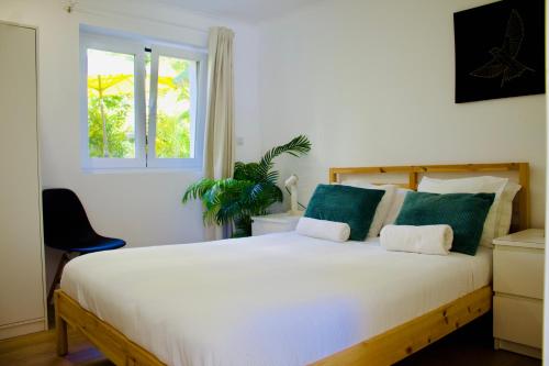 a bedroom with a large white bed with a window at White and Light House in Costa da Caparica