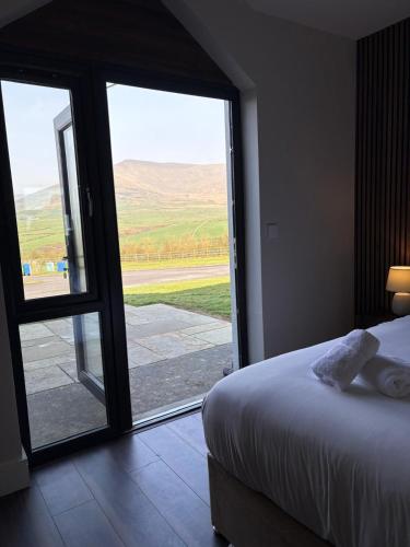 a bedroom with a bed and a large glass door at Dingle Lispole Garden Suite 6 in Lispole