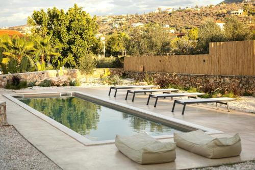 a pool with picnic tables and benches in a yard at Plaka Oasis - Private Pool - Walk to Beach & Shops in Plaka