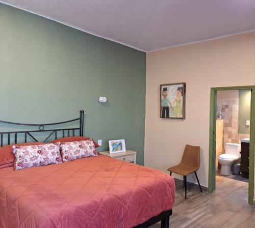 a bedroom with a bed and a toilet and a chair at Alojamiento Privado San Jose Viejo BCS in San José del Cabo