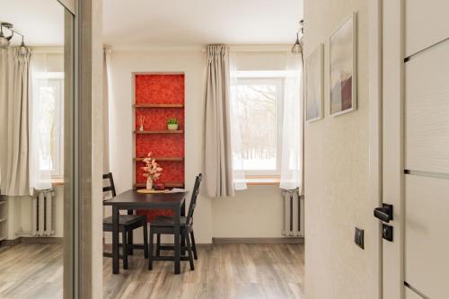 a dining room with a table and chairs and a window at Park-View Studio Apartment with Free Parking - 10 min to Old Town in Riga